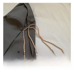 Detail of pink faux fur box bag showing golden metal chain and spherical zipper charms