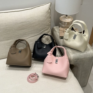 Detail view of four leather bucket bags in brown, black, pink and white with metal locks