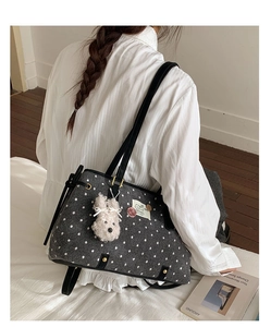 Detail of grey polka dot tote bag with plush puppy charm and cat patch decor