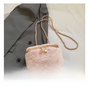 Detail of pink faux fur mini box bag featuring gold chain and dice zipper puller