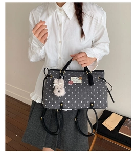 Grey polka dot felt tote bag with rabbit charm shown in a minimalist room setting