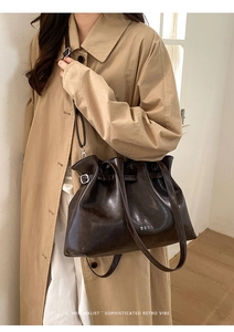 Detail of dark brown tote bag featuring cloud pleated opening and shiny leather texture