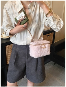 Detail of pink faux fur mini box bag featuring metal chain strap and dual zippers