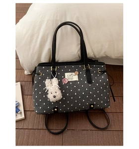 Grey felt tote bag with white polka dots, black straps and a plush rabbit charm