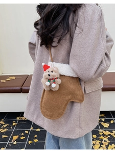 Détail d'un sac bandoulière marron en forme de moufle avec polaire et petit ours en peluche