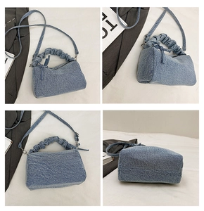 Détail du sac polochon en jean bleu avec poignée plissée et fine bandoulière réglable