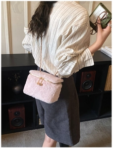Detail view of pink plush mini box bag with gold chain strap shown on model's shoulder