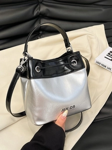 Silver and black contrast bucket bag with drawstring closure and metal logo detail
