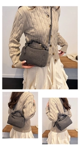 Détails d'un sac polochon en denim gris foncé avec anses plissées et bandoulière fine