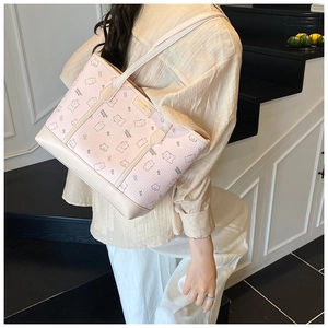Détail d'un sac cabas rose imprimé ours porté par un mannequin dans un décor intérieur moderne