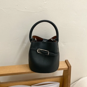 Détail du sac seau en cuir noir grainé avec boucle argentée et intérieur marron
