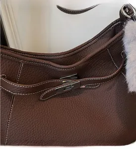 Detail of brown litchi pattern leather bag with silver twist lock and white stitching