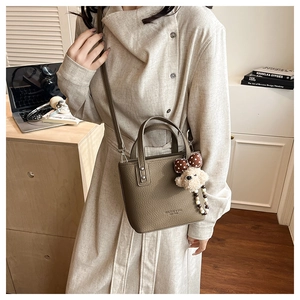 Chic olive green bucket bag with a cute bear pendant and polka dot bow detail