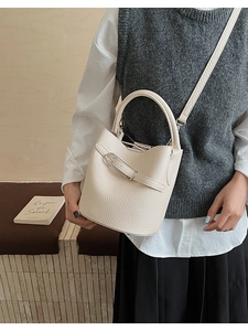 Detail of off-white lychee texture bucket bag with silver buckle and round base