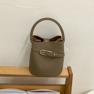 Détails du sac seau en cuir grainé avec boucle métallique argentée et texture lychee