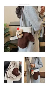 Detail view of brown glove-shaped plush bag with white fleece trim and teddy bear pendant