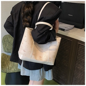 Détail du sac cabas crème avec motifs d'ours embossés porté par le mannequin