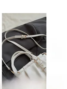 Detailansicht der weißen Lederhandtasche mit goldener Schnalle und verstellbarem Gurt