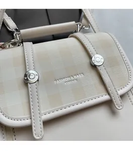 Detail of beige checkered handbag showing premium leather texture and silver hardware