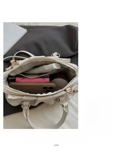 Innenansicht der weißen Plissee-Tasche mit Platz für Handy und rosa Brieftasche