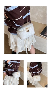 Close-up of white plush mini box bag with gold chain and dice-shaped zipper pulls