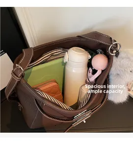 Deep brown leather crossbody bag featuring spacious interior with striped lining and items