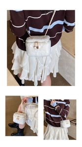 Detail showing white faux fur mini box bag with golden dual zippers and chain strap