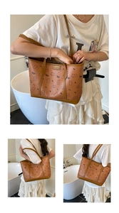 Détail d'un sac cabas marron avec motif d'ours et plaque logo métallique dorée élégante