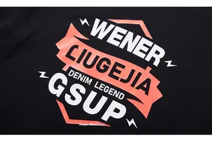 Detail of urban streetwear T-shirt with orange and white letter prints on black cotton fabric