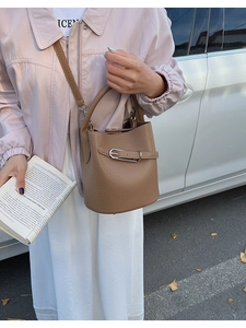 Close-up of a camel lychee pattern bucket bag with metal buckle and shoulder strap