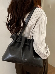 Black pleated leather tote bag with Korean lettering shown on a model's shoulder