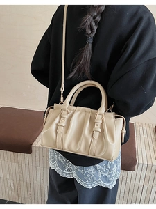 Detail of beige pleated handbag showing textured surface and versatile shoulder strap style