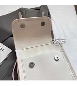 Detail view of cream PU leather bag with magnetic closure and plaid fabric lining