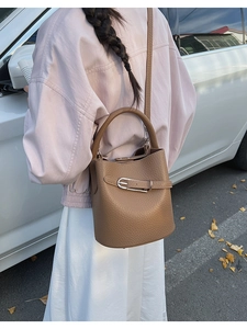 Close-up of caramel lychee grain leather bucket bag with silver buckle detail