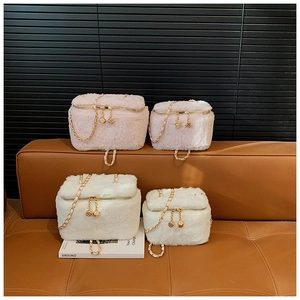 Detail of plush mini box bag with golden chain straps and dice zipper heads