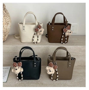 Litchi pattern leather bucket bags with plush bear charms in four neutral colors