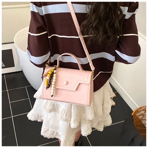 Pink leather shoulder bag detail with colorful wooden beads and adjustable long strap