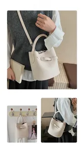 Close-up of beige lychee texture leather bucket bag with silver hardware and buckle