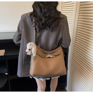 Detail of brown litchi leather hobo bag with silver buckle and plush rabbit charm
