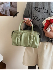 Detail of light green pleated leather Boston bag with decorative gold hardware straps