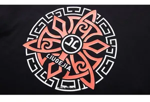 Detail of a black T-shirt featuring a complex orange and white geometric circular print
