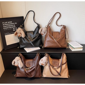 Hobo bags in four colors with plush rabbit charms and adjustable straps on display