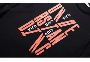 Primo piano di una t-shirt nera a maniche lunghe con stampe artistiche arancione corallo