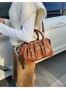 Detail der braunen Vintage-Ledertasche mit Plissee-Struktur und Metallbeschlägen