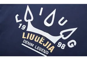 Detailed view of crown logo and gold lettering on navy blue long sleeve t-shirt