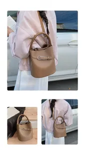 Detail of brown lychee texture bucket bag with unique silver pin buckle and strap