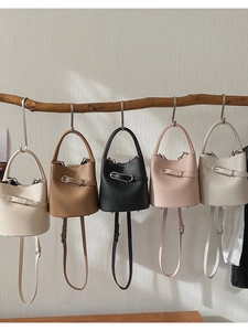 Litchi pattern leather bucket bags in five colors displayed on a wooden stand