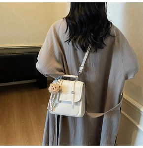 White mini crossbody bag with beige plaid pattern and cute brown teddy bear pendant detail