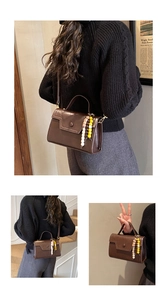 Detailed view of coffee brown crossbody bag with glossy finish and beaded charm