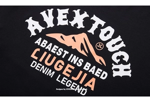 Detail of street style graphic print with orange lettering on black oversized long sleeve tee